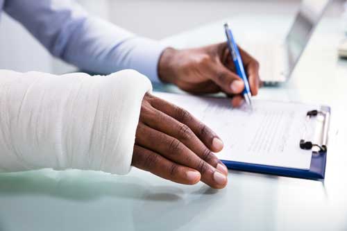 An injured man signing a document