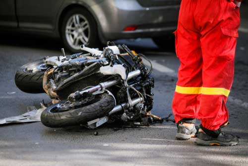 A damaged motorcycle lying in the middle of the road, after an accident.